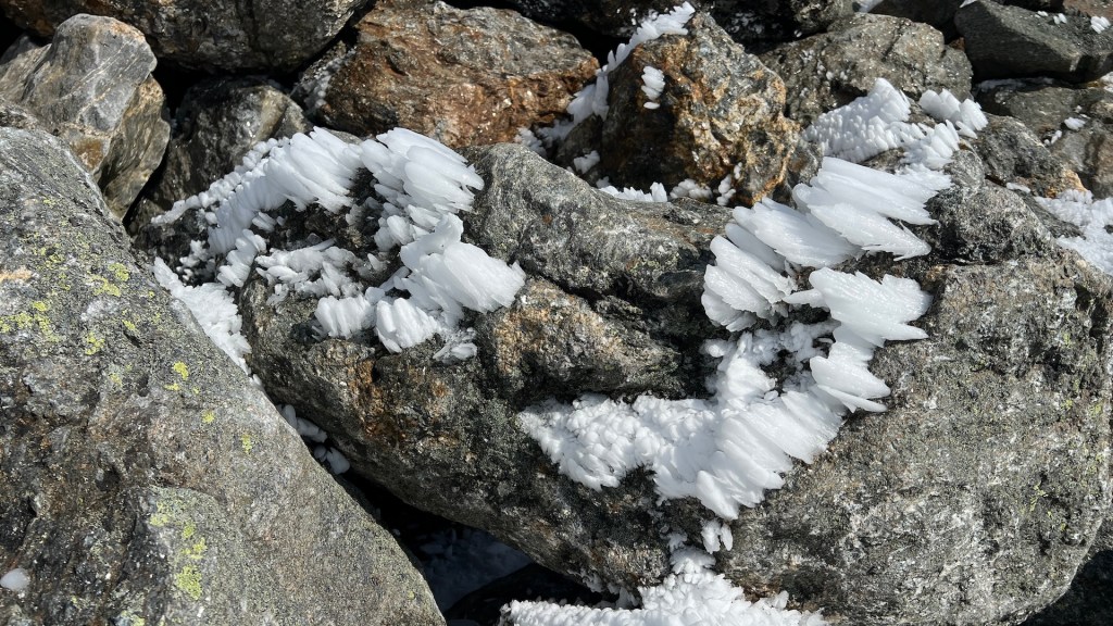 Close-up of rocks covered with ice crystals in a rugged outdoor setting.